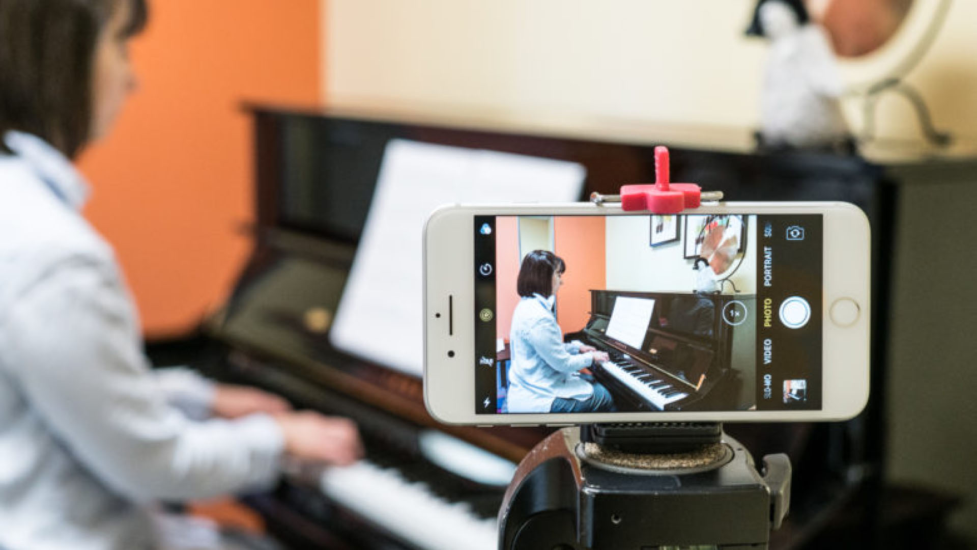 A phone set up to record a piano performance of a student