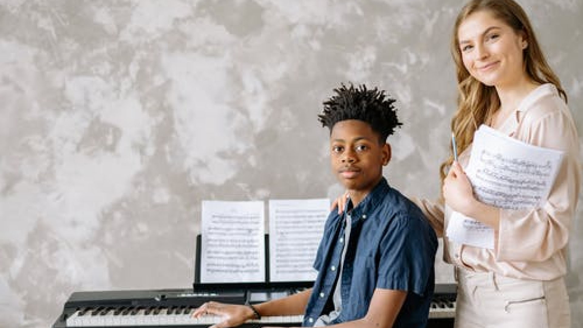 Two teenagers at a digital piano