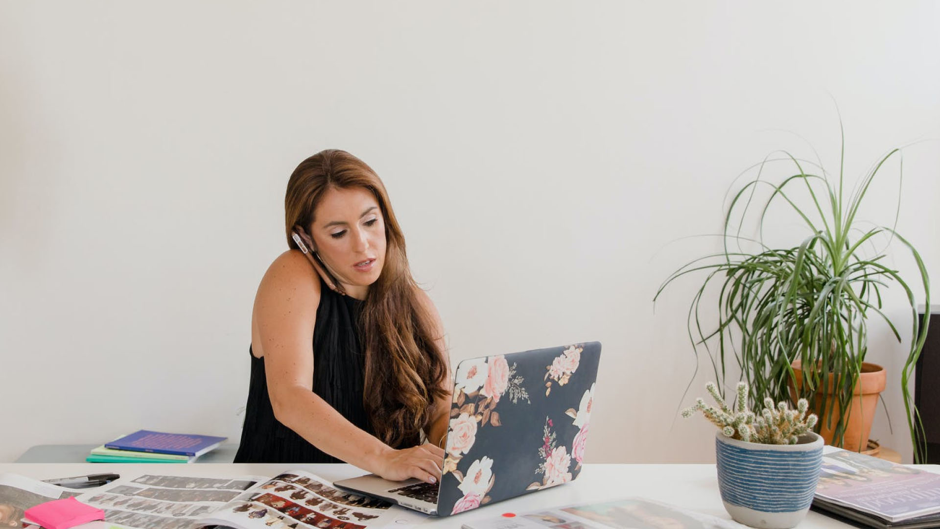 A woman working at her laptop and talking on the phone